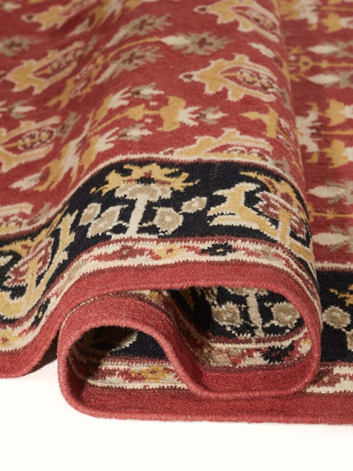Close-up of Traditional floral kilim rust salawas wool & cotton panja dhurrie emphasizing the detailed weaving and color richness
