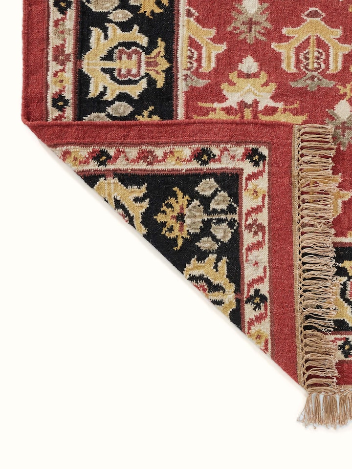 Detailed view of Traditional floral kilim rust salawas wool & cotton panja dhurrie highlighting the geometric and floral elements