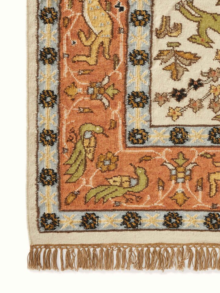 Angled view of Kilim hunting salawas wool & cotton panja dhurrie, illustrating its use and overall design in a room setting.