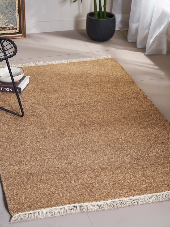 Lifestyle shot of a solid textured sumak brown wool rug, featured in a modern living room setting.