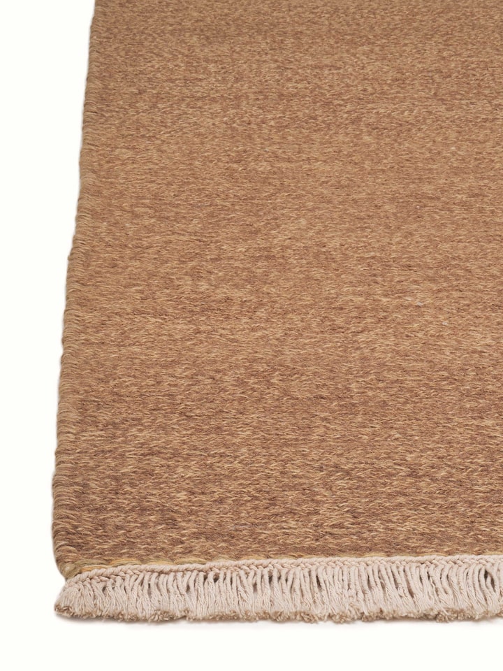 Angled view of a solid textured sumak brown hand-knotted rug, highlighting the detailed weaving and rich color.
