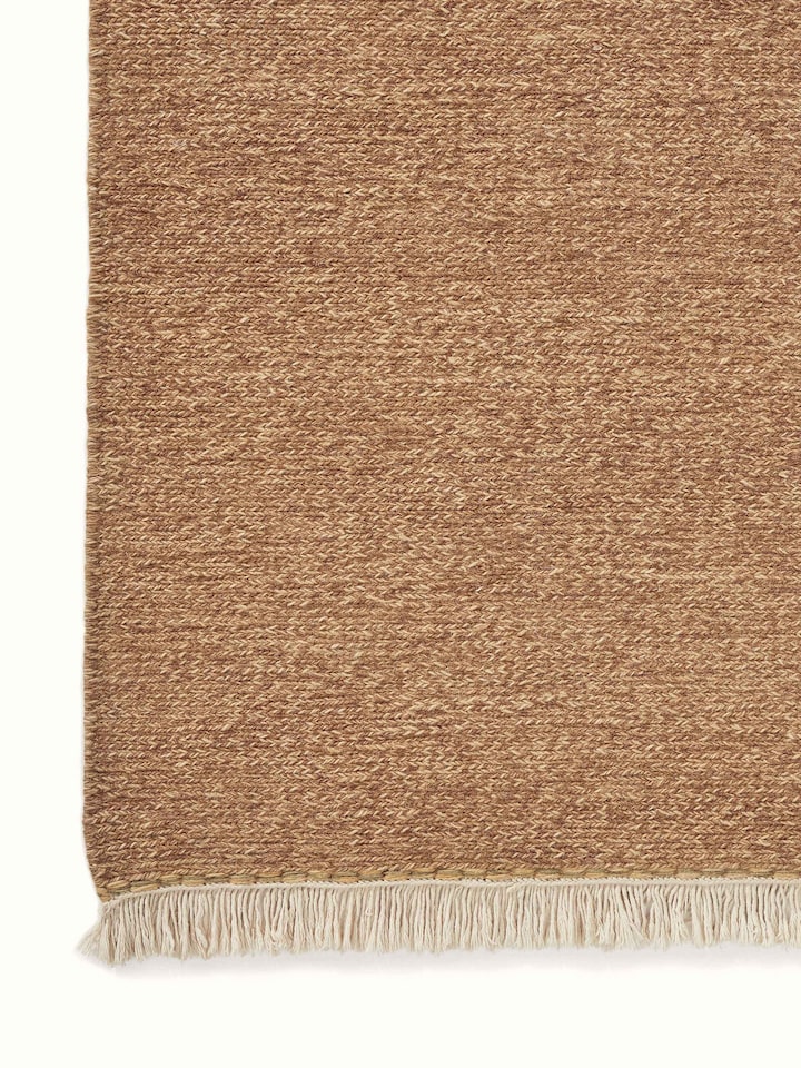 Close-up image of the sumak texture on the brown wool rug, showcasing the craftsmanship.