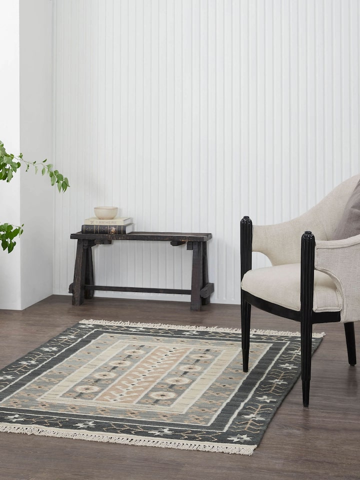 Lifestyle shot: Contemporary grey Panja wool dhurrie featuring geometric design, styled in modern space.