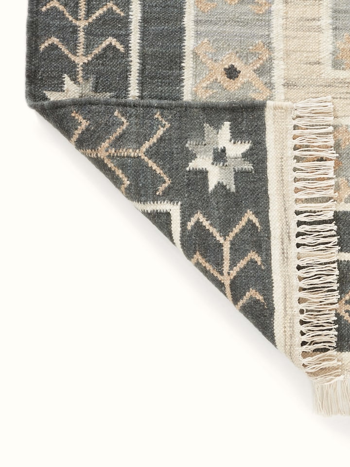 Folded Contemporary geo grey wool panja dhurrie displaying its wool texture and design in a compact form.