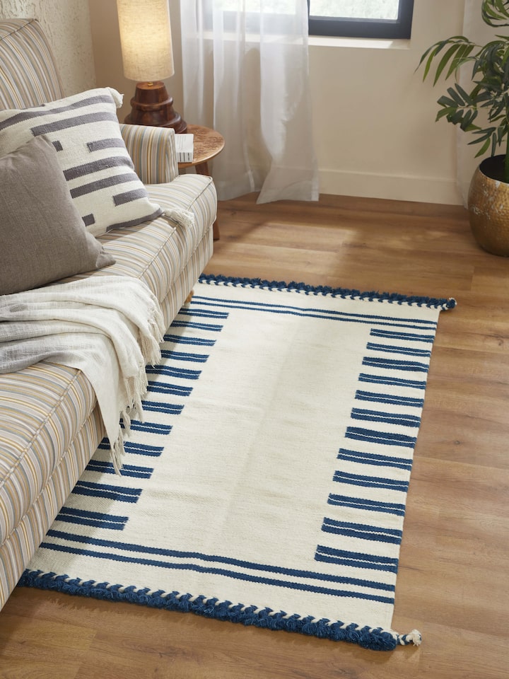 Close-up of Geo Border Ivory Blue Gujarat Wool & Cotton Panja Dhurrie, highlighting the intricate border patterns and texture.