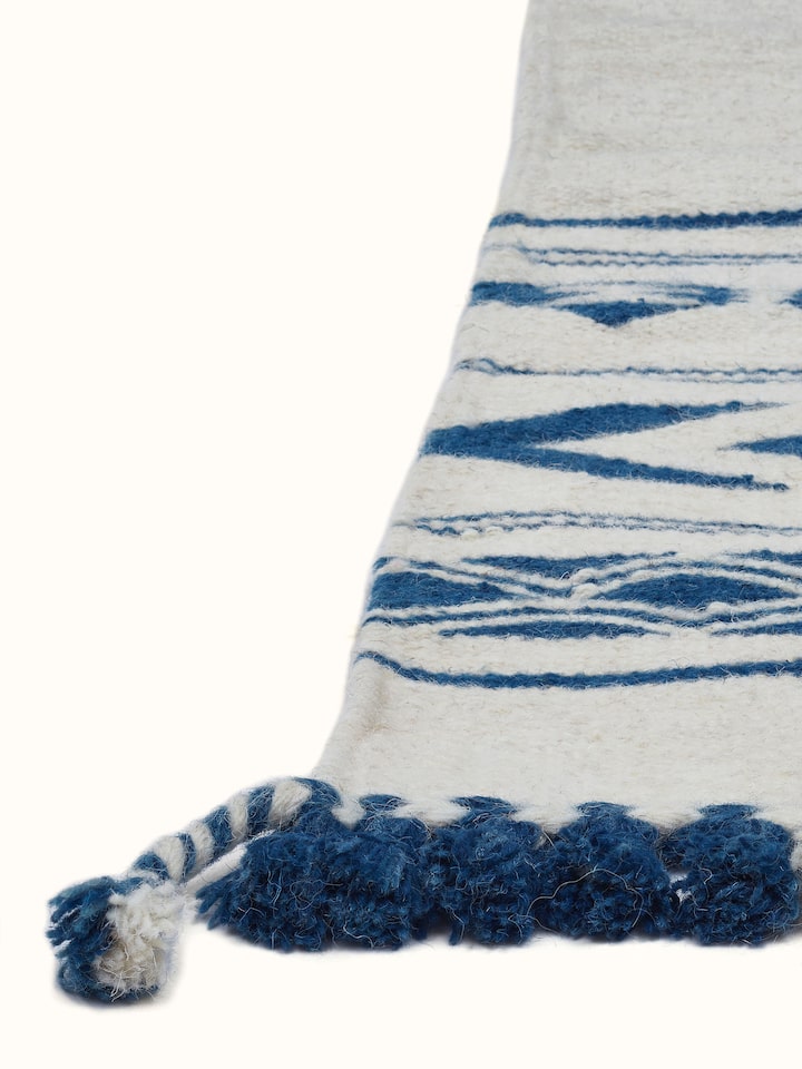 Traditional Geo Ivory Indigo Gujarat Wool & Cotton Panja Dhurrie Kharad displayed on a floor, highlighting its design and colors.