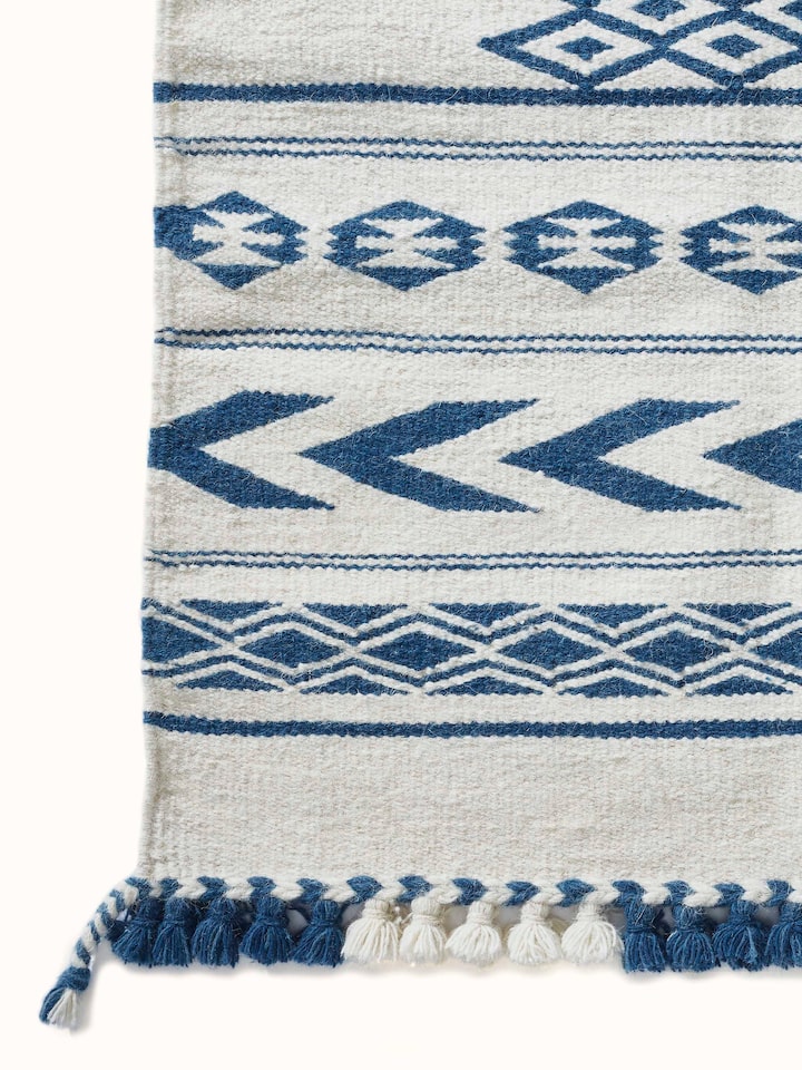 Side view of the Traditional Geo Ivory Indigo Gujarat Wool & Cotton Panja Dhurrie Kharad, emphasizing its texture and thickness.