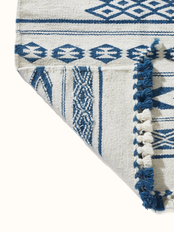 Traditional Geo Ivory Indigo Gujarat Wool & Cotton Panja Dhurrie Kharad in a room setting, showcasing its use as a decorative rug.