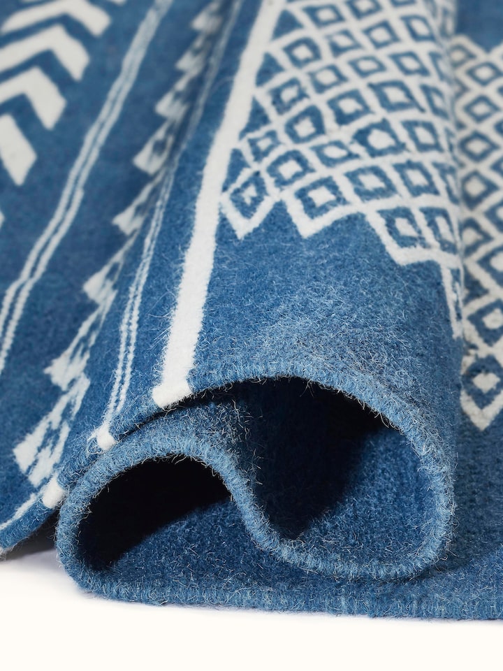 Traditional Geo Indigo Ivory Gujarat wool & cotton panja dhurrie kharad (4x6 ft) folded, showcasing the texture and design pattern.