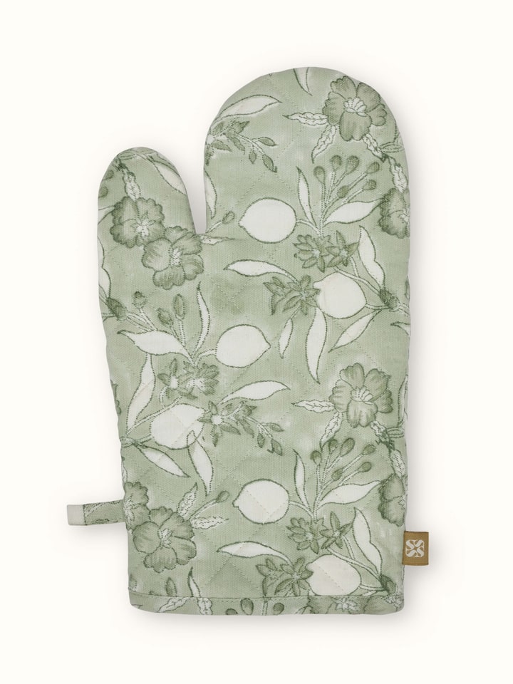 Green floral cotton Sanganeri block printed oven mitts displayed with focus on their functionality and print.
