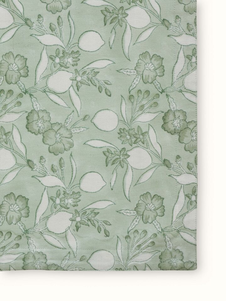 Close-up of green floral cotton Sanganeri block printed apron emphasizing the floral print and fabric detail.