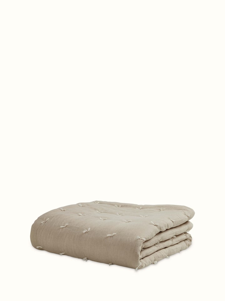 Angled view of Anuthi Beige Solid Linen Razai Embroidered Double Quilt, showing the full design and luxurious linen texture.