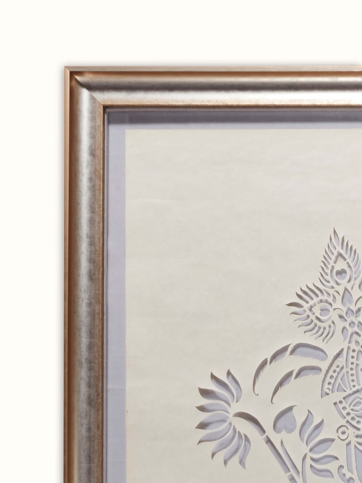 Close-up of Sanjhi paper stencil wall art focusing on the delicate paper cut-out work and artistic details