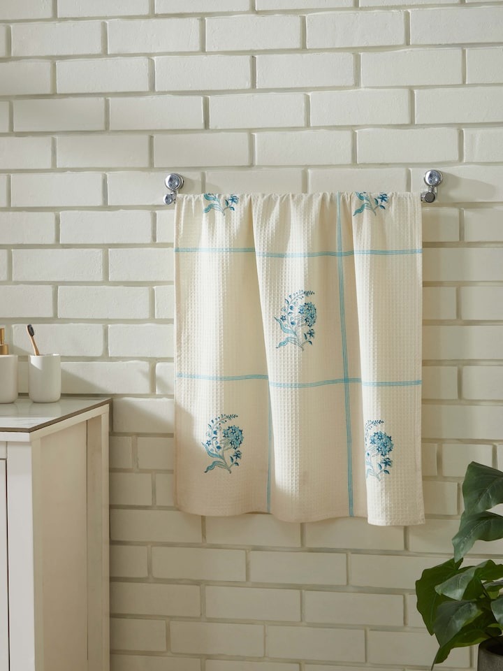 Close-up of Palampore Buta blue floral cotton Sanganeri block printed bath towel (L) highlighting the detailed block print and fabric texture.