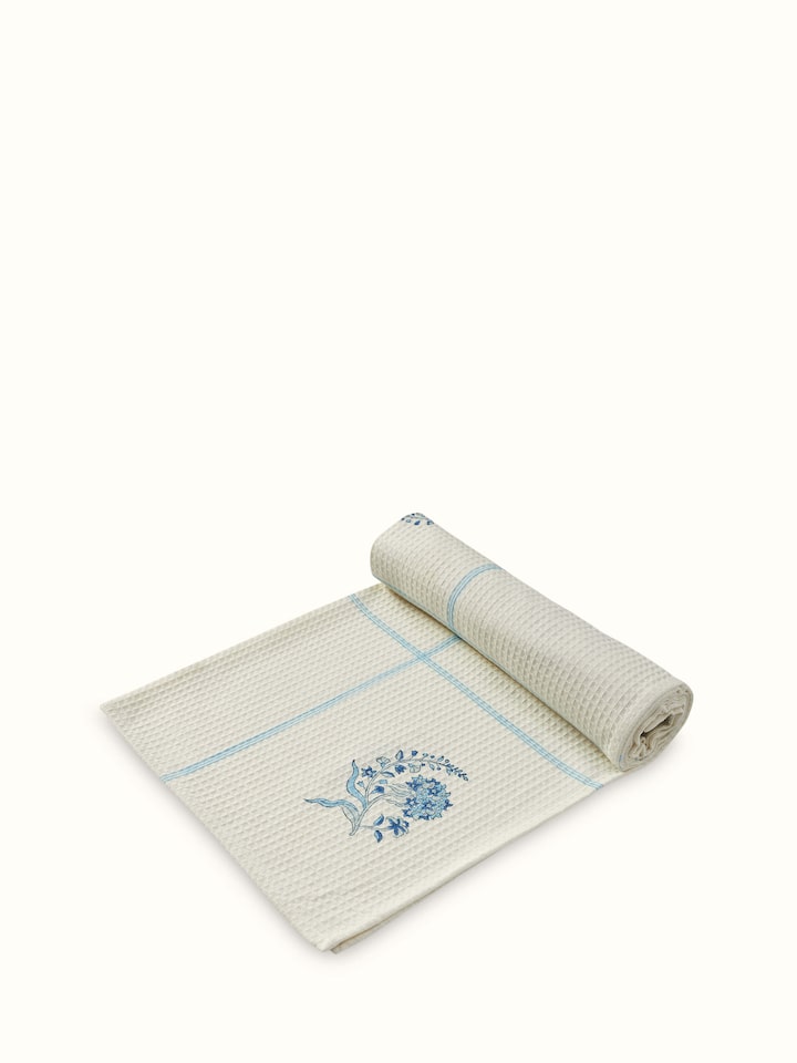 Side view of Palampore Buta blue floral cotton Sanganeri block printed bath towel (L) showing the design and fabric quality of the towel.