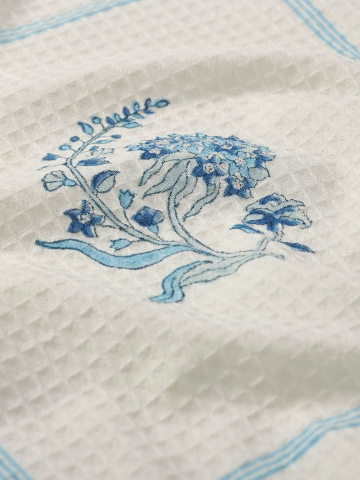 Detailed view of Palampore Buta blue floral cotton Sanganeri block printed bath towel (L) focusing on the floral block print and cotton softness.