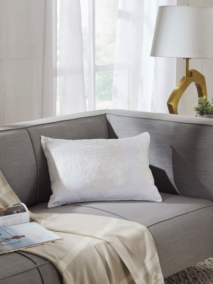 Close-up of Razza ivory carnation allover linen crewel hand-embroidered cushion cover, highlighting the detailed hand-embroidered floral design