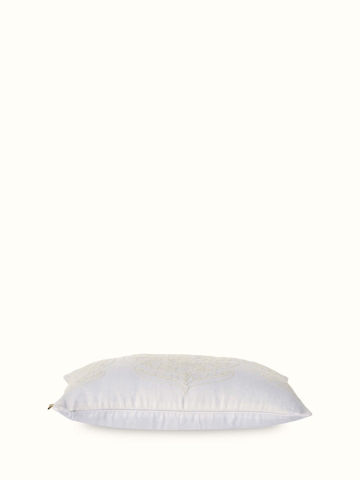 Angled view of Razza ivory carnation allover linen crewel hand-embroidered cushion cover, showing the texture and design of the embroidery