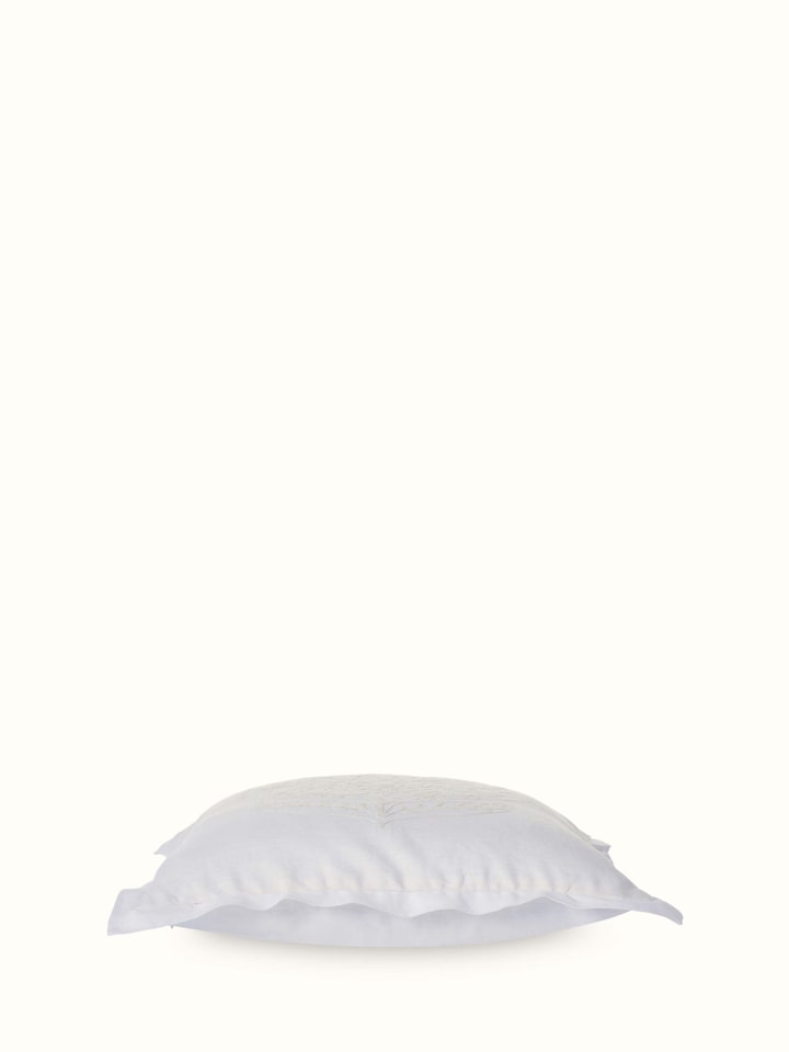 Angled view of Razza ivory carnation buta linen crewel hand-embroidered cushion cover displaying its design and texture