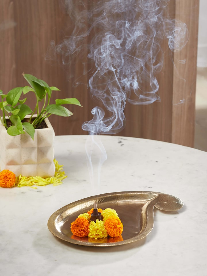 Side view of Polished brass paisley pooja thali highlighting its elegant curves and detailed pattern.