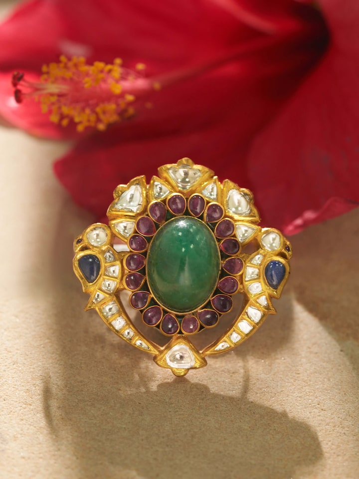 Detail shot of gold ring showing enamel work and gemstone cluster