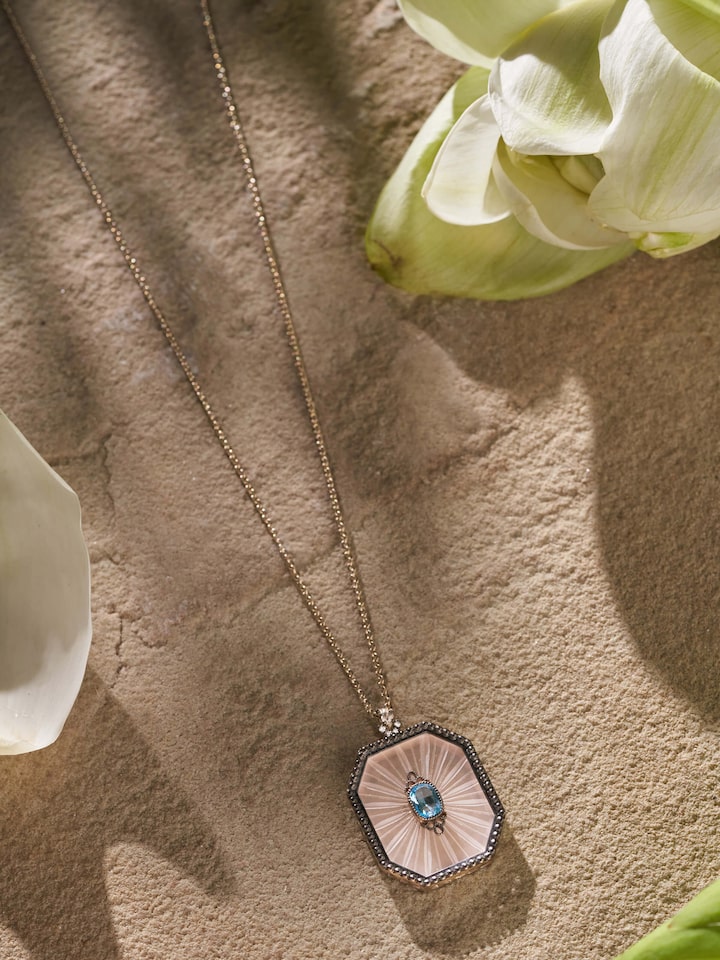 Lifestyle shot of Lapidary gold pendant worn with formal attire for a refined appearance.