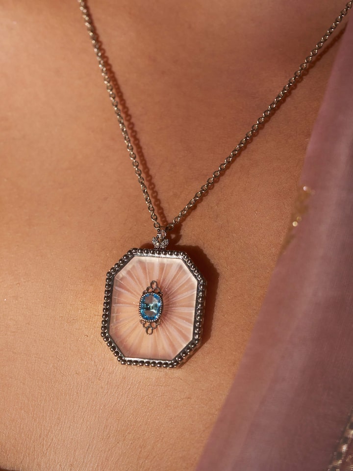 Detail shot of Lapidary gold pendant showing gemstone cut and polished gold surface.