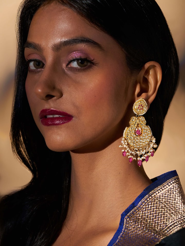 Close-up of 22 karat gold drop earrings emphasizing the intricate details and gold quality