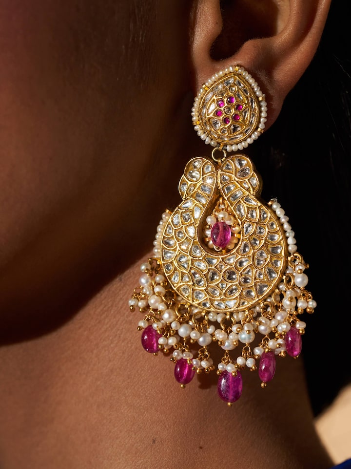 Detailed view of 22 karat gold drop earrings highlighting their luxurious finish