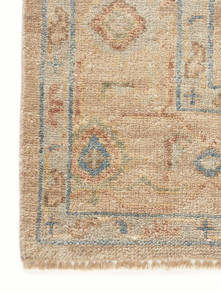Full view of Oushak traditional beige Bhadohi wool hand-knotted rug laid out, emphasizing its size and traditional design