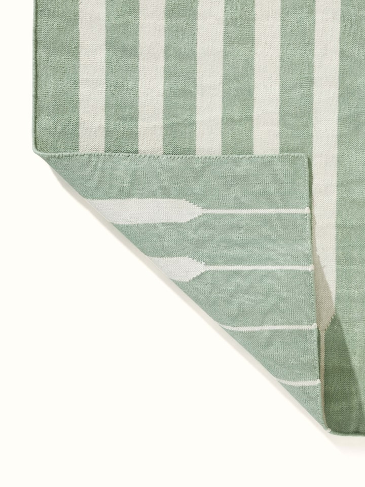 Modern geo stripe light green ivory lawan cotton panja dhurrie kharad focusing on the color contrast between light green and ivory stripes.
