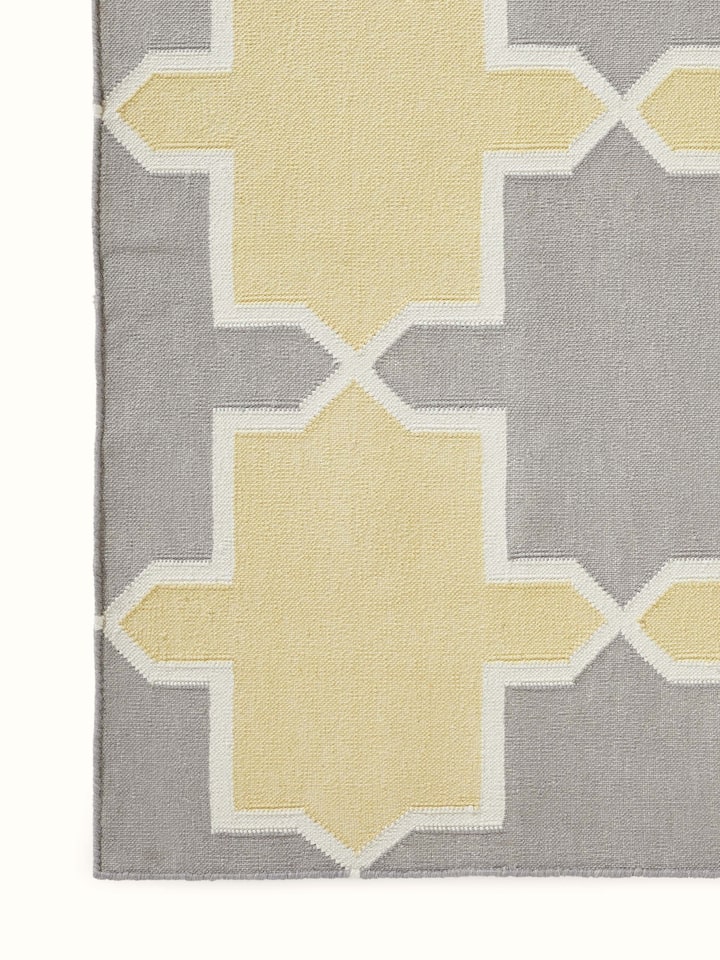Side view of Modern Geo grey yellow Lawan cotton panja dhurrie showing the thickness and edge design