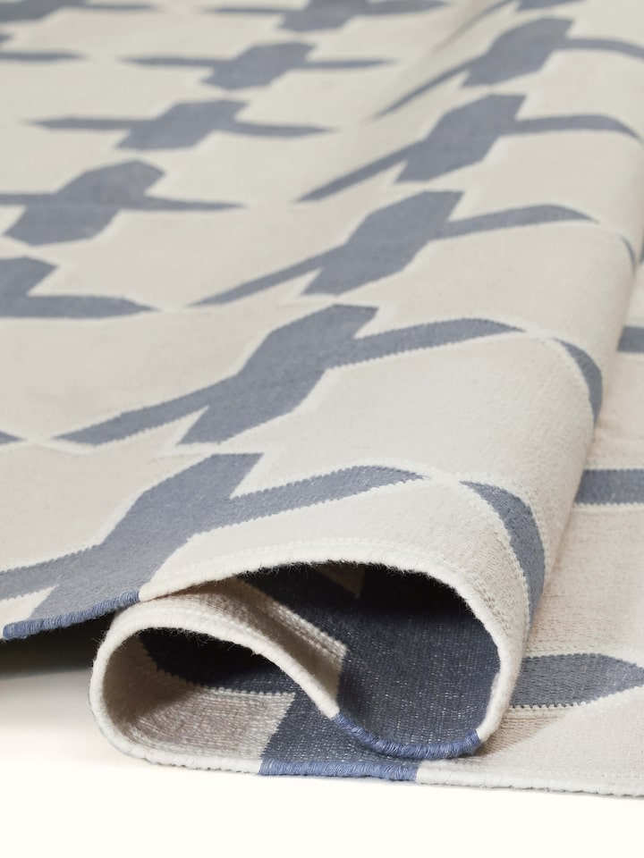 Modern geo jharokha grey blue lawan cotton panja dhurrie displayed on the floor, highlighting its size and design.