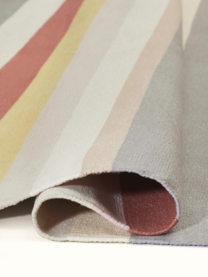 Perspective view of Modern geo stripe rust lawan cotton panja dhurrie showcasing the overall design and rust color.
