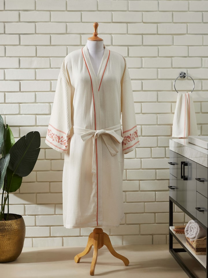Angled view of Palampore buta peach floral cotton Sanganeri block printed bathrobe highlighting the fabric and print