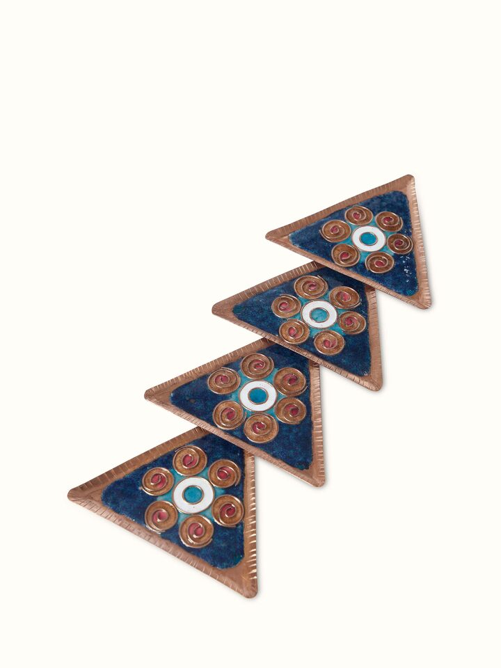 Close-up view of Triangular copper coaster focusing on texture and design