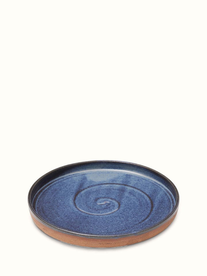 Top view of studio pottery ceramic blue dessert plate emphasizing its smooth surface and subtle color variations