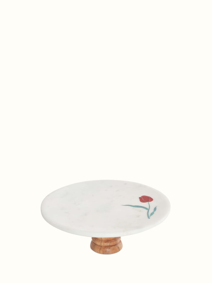 Angled view of marble inlaid cake stand focusing on the delicate craftsmanship of the inlaid patterns.