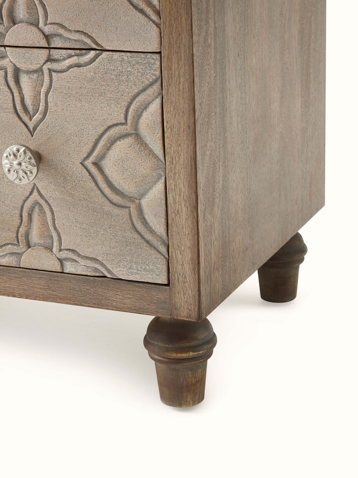 Detailed view of the mango wood chest of drawers, emphasizing the wood grain and carved designs