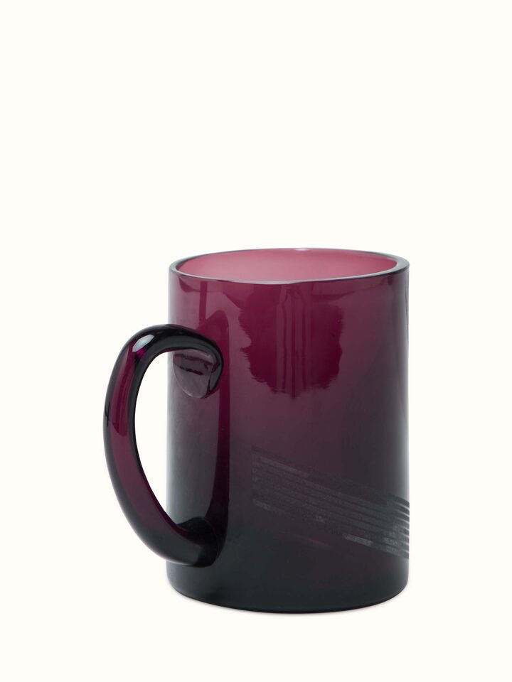 Angle view of Firozabadi Glass Coffee Mugs in magenta, showcasing the mugs' contours and glasswork.