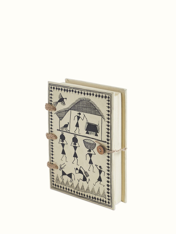 Close-up of Warli painted paper planner brown focusing on its detailed Warli paintings and texture