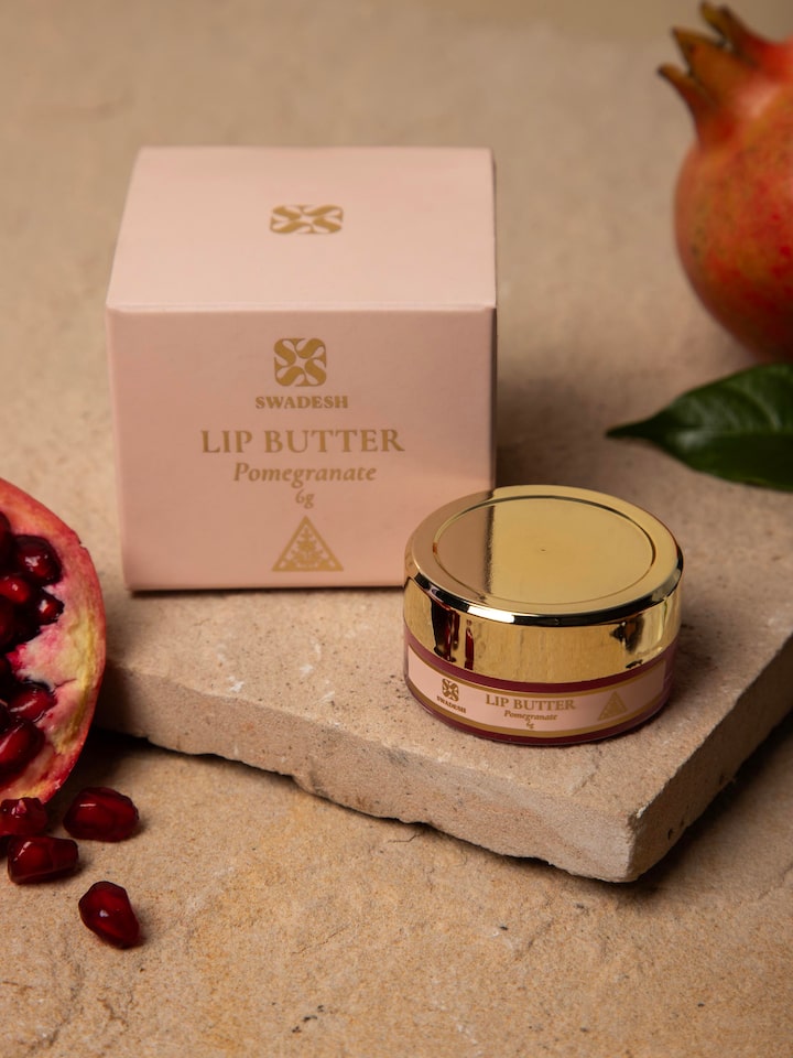 Close-up of Lip Butter Pomegranate jar focusing on the label and the rich color of the butter inside.