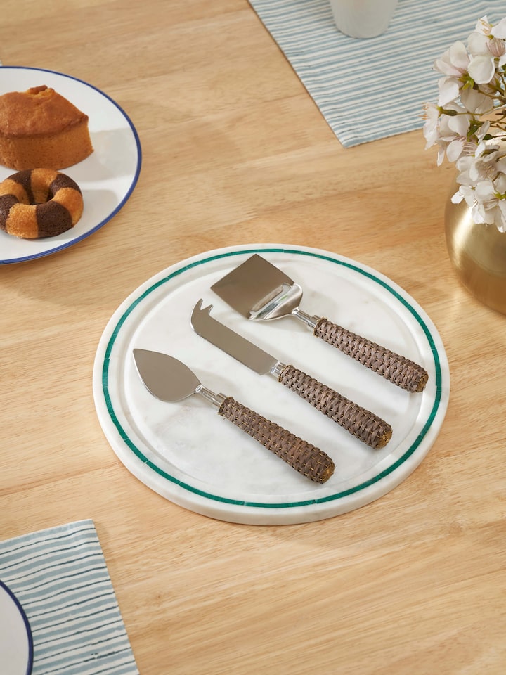Close-up view of the stainless steel cheese knives with rattan handles, showcasing the elegant design and craftsmanship.