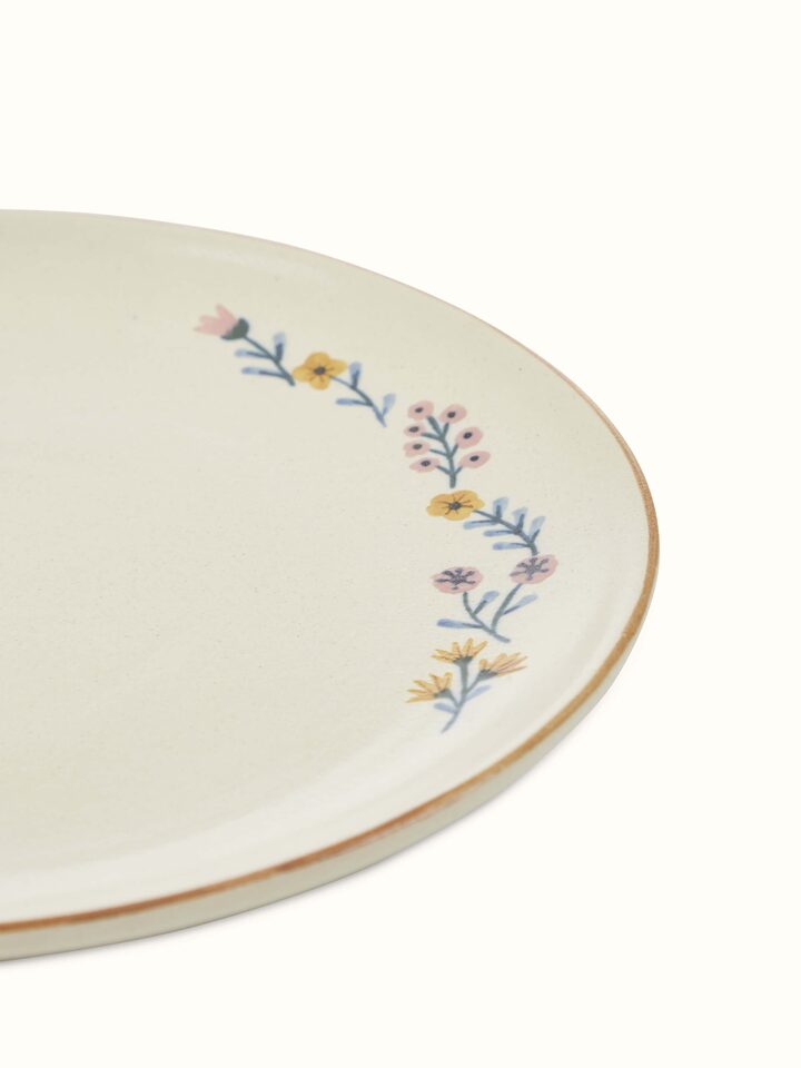 Close-up of beige studio pottery ceramic dinner plates set of 4, focusing on the texture of the glaze