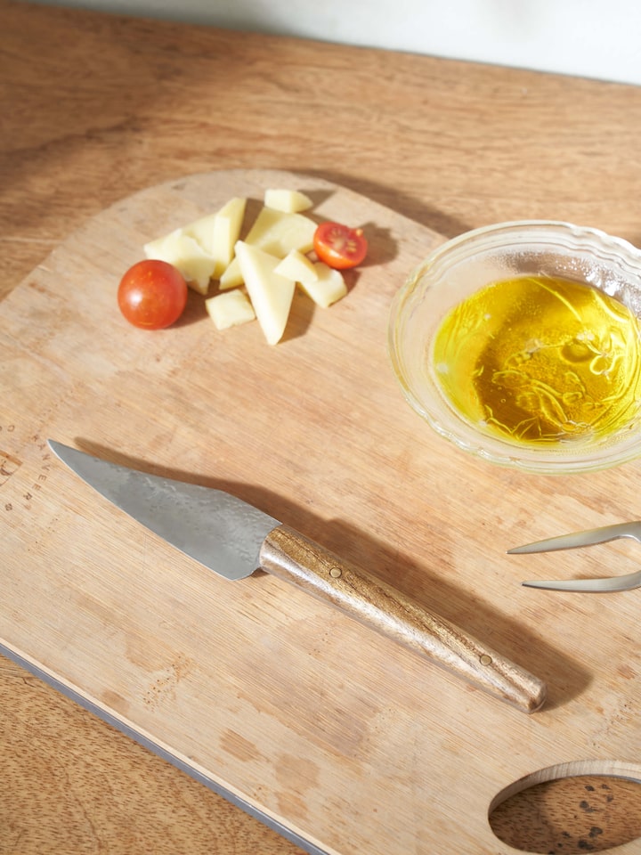 Side view of Reha stainless steel chef's knife focusing on the blade's sharpness and handle design.
