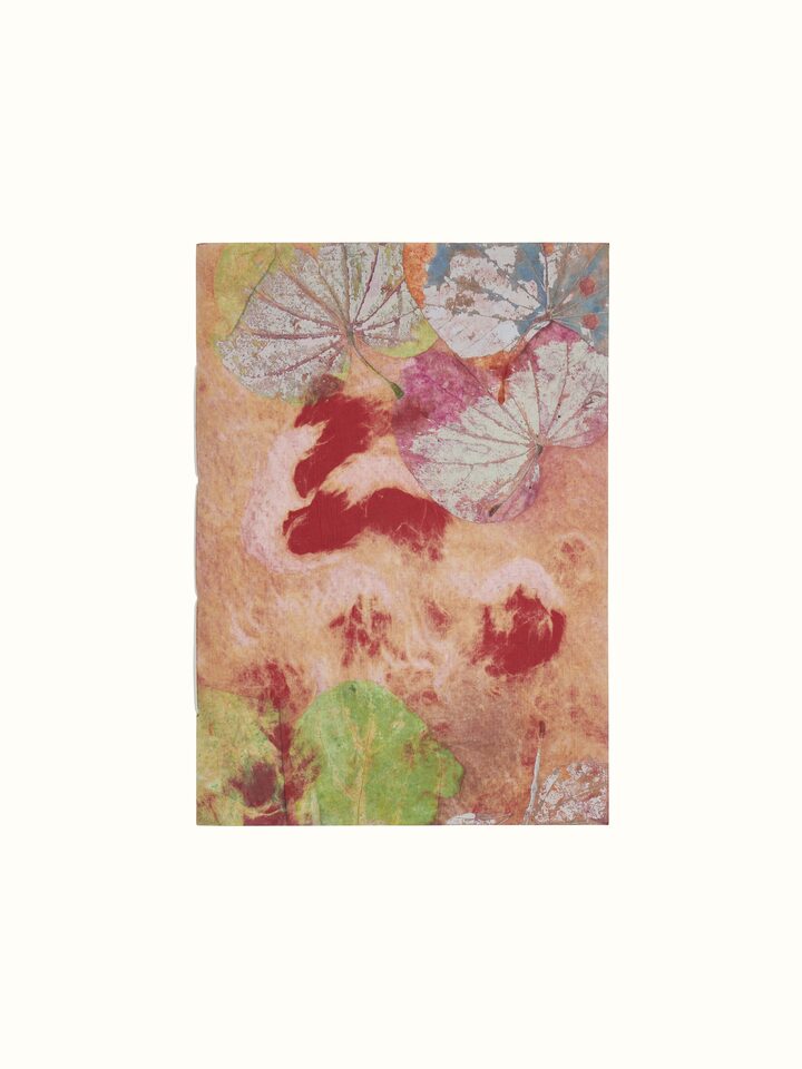 Top view of Auroville handmade paper notebook in orange showcasing its detailed paper texture and binding.