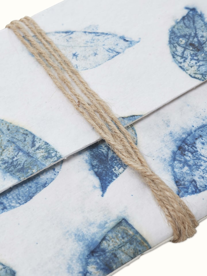 Detailed view of Auroville handmade paper notebook with blue rope binding, emphasizing the quality of paper