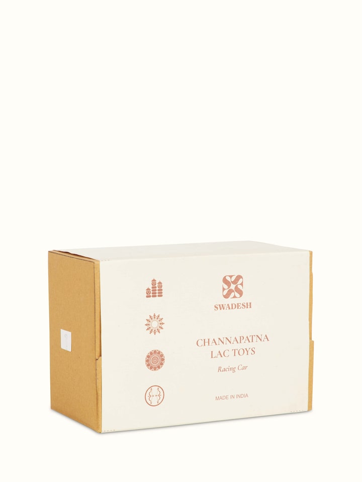 Close-up of Channapatna ivory wood vroom toy in red, emphasizing the smooth wooden finish and bright color.