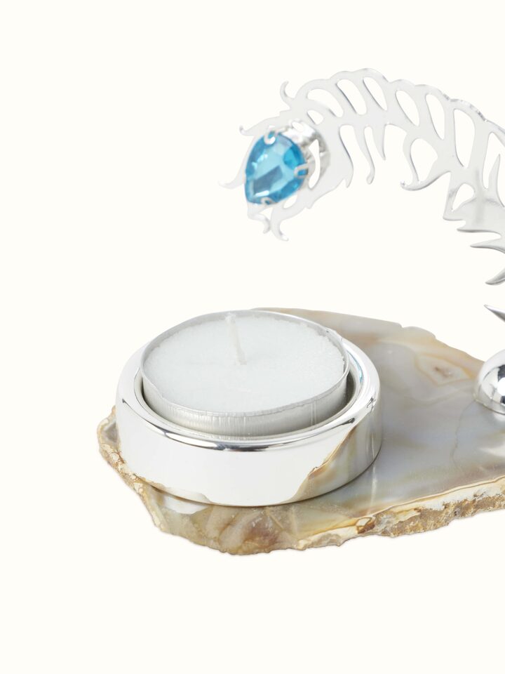 Close-up of Silver-plated peacock feather tea light holder focusing on the blue gemstone and detailed craftsmanship