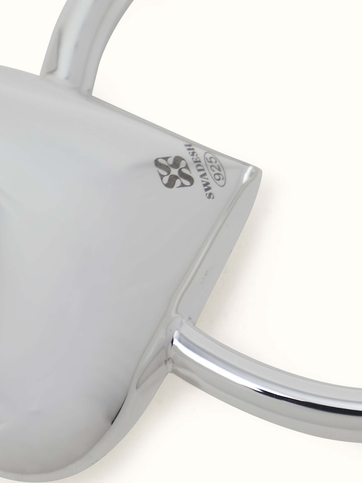 Side view of Silver Heart Rattle Toy showing the curved shape and reflective surface.